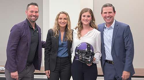 Sales faculty and students, one of whom is holding a TCU football helmet.