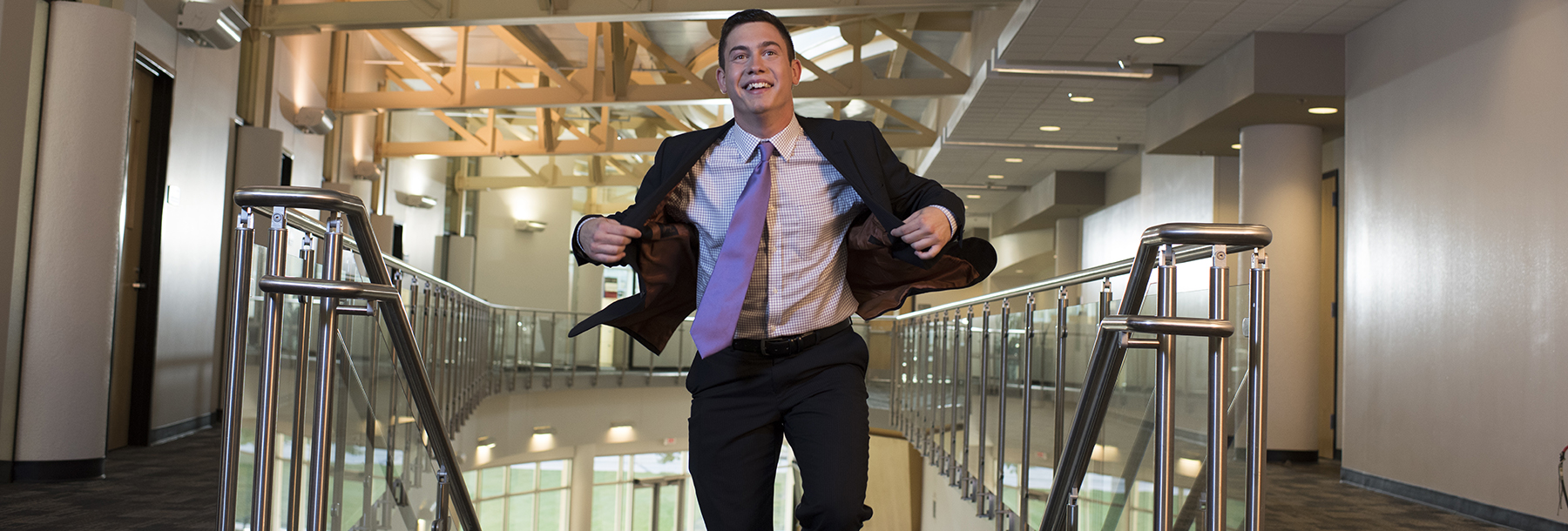 Section Image: Student in a suit coming up the stairs in Smith Hall. 