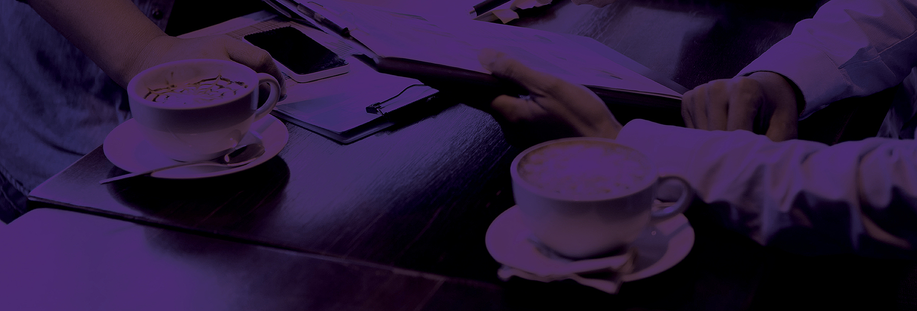 Section Image: Cup of coffee and books and phone on a table 