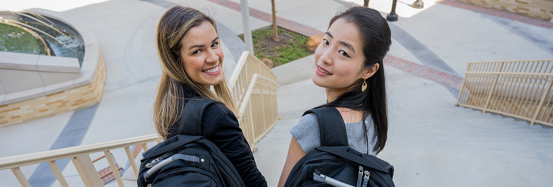 Section Image: Two girls with backpacks walking down the stairs outside of the Neeley Business Commons. 