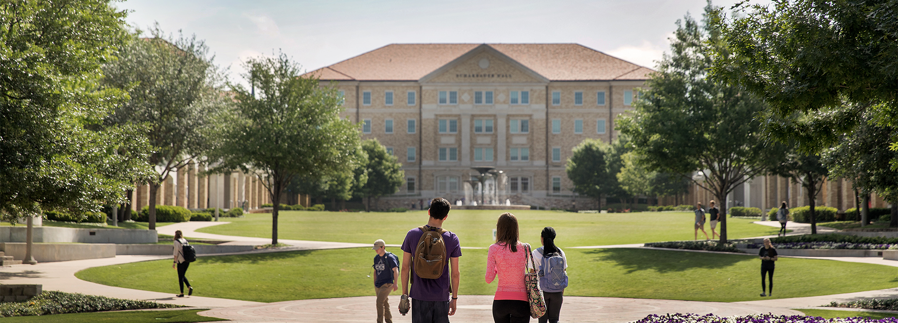 Section Image: Students walking through TCU Campus with Frog Fountain in the distance 