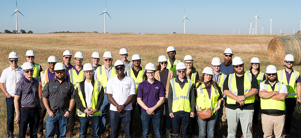 Section Image: Group in hardhats with windmills in distance 
