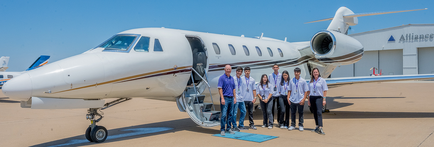 Section Image: Group of students with a leer jet at Alliance Airport 