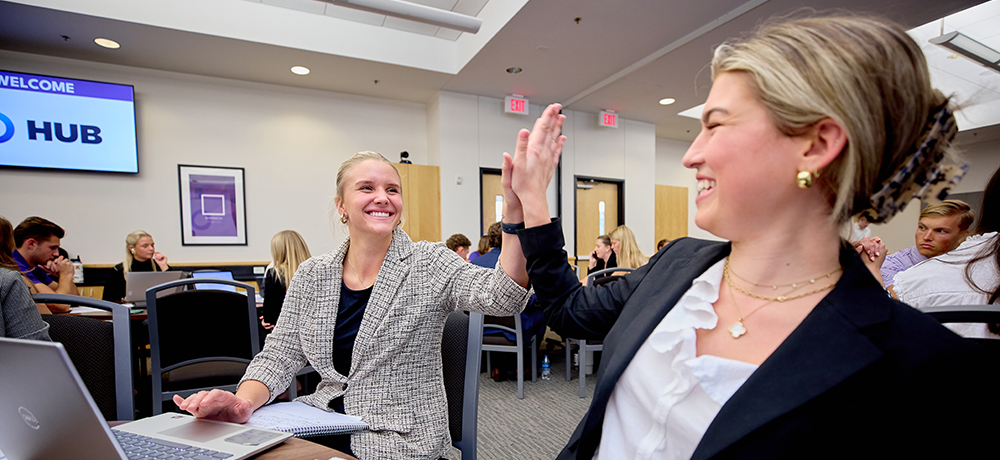 Two female students giving a high five