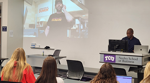 Students and Professor Elijah Clark watch Super Bowl ads