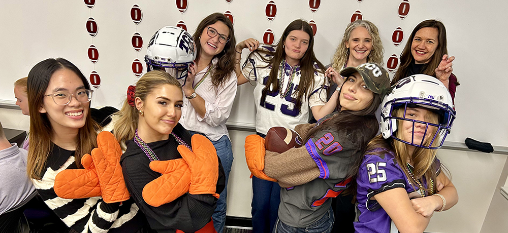 TCU students with football helmets and mitts