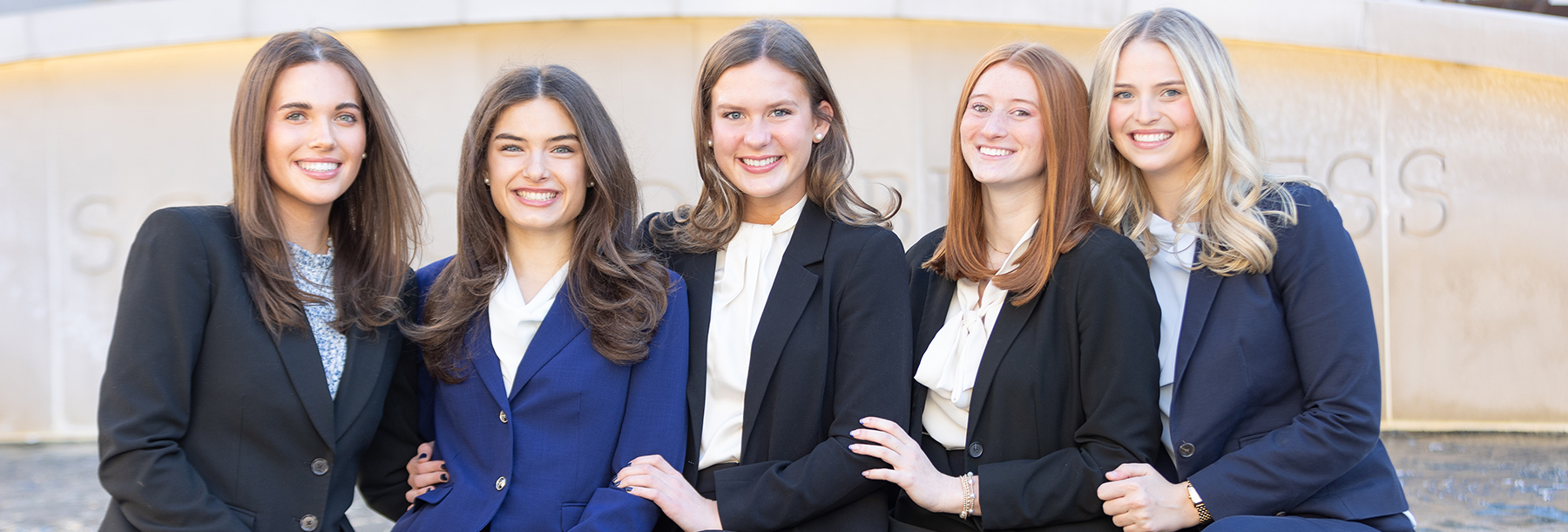 Section Image: Females of the Neeley Fellows Student Organization Board in front of the Neeley Fountain 