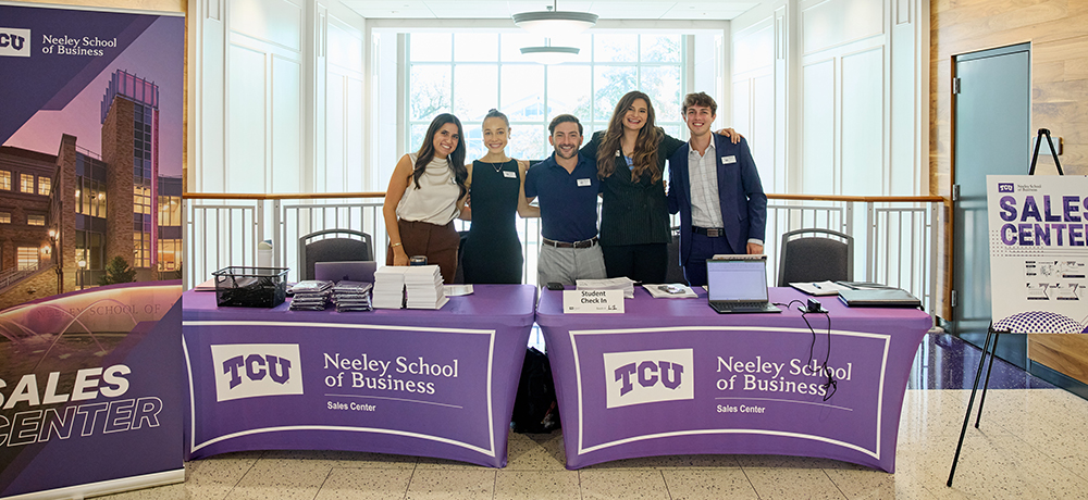 Section Image: Sales students at welcome tables 