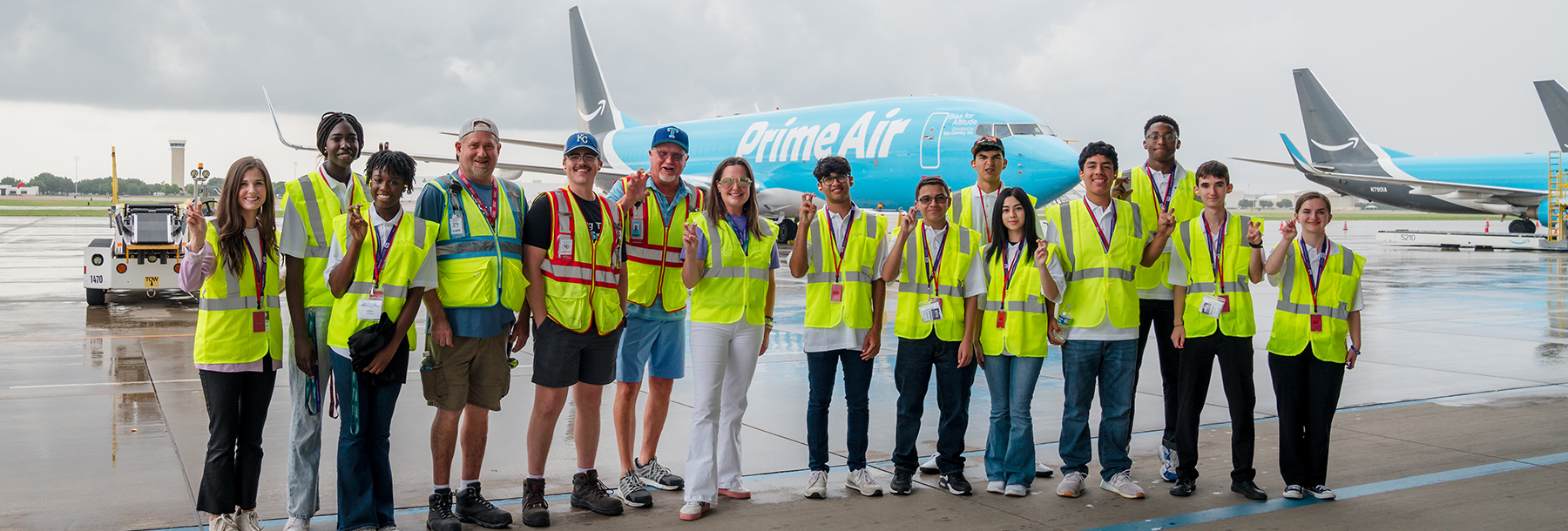 Section Image: Group of BizTech Camper on the tarmac in front of airplanes 