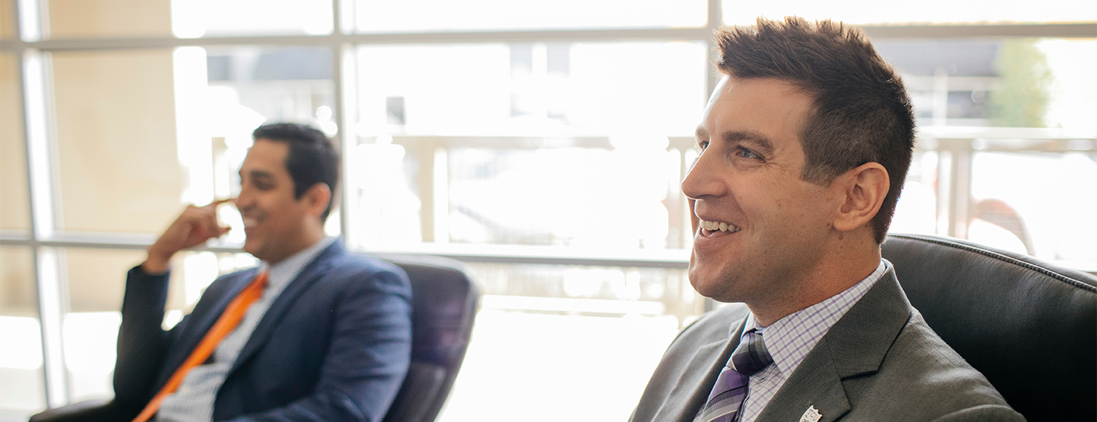 Two adults smiling during a supply chain presentation
