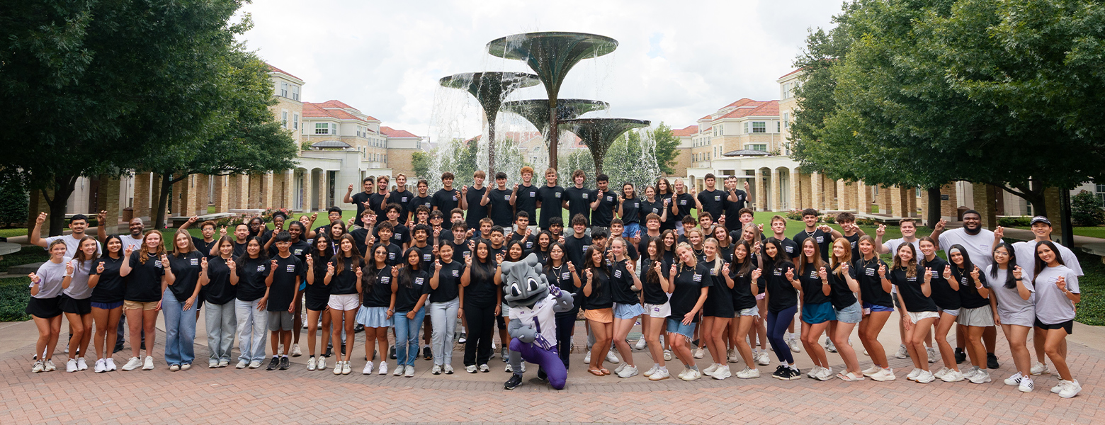 High school students attending Neeley's Business Innovation Academy pose with Super Frog on campus