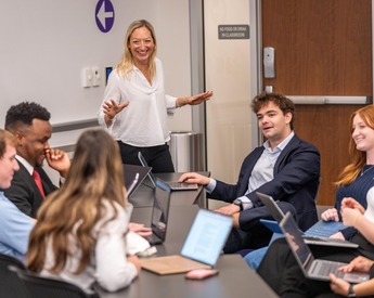 Students using laptops with TCU Neeley professor