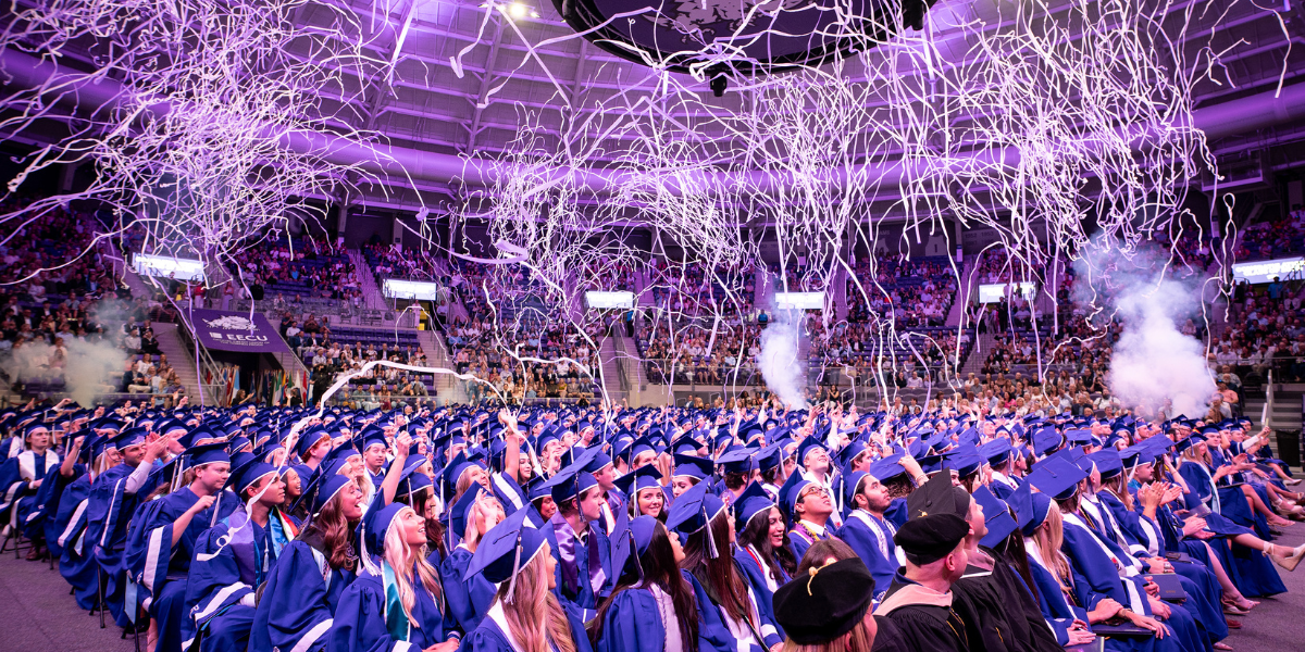 Graduates celebrate under display of confetti and streamers at Neeley convocation.