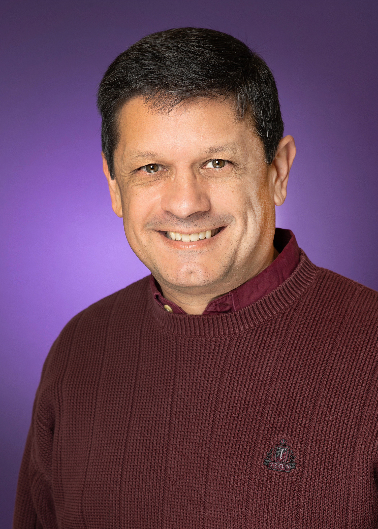 Headshot for Mo Rodriguez with purple background.