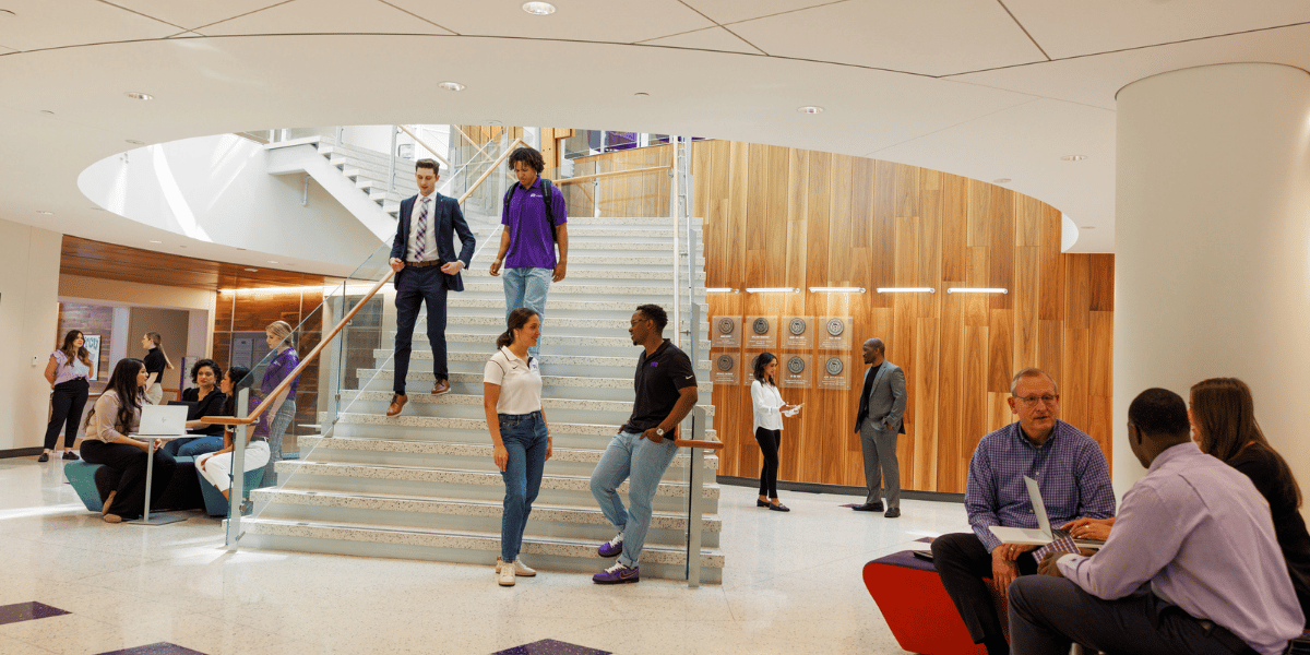 Students and faculty gather at the base of the stairway in Rogers Rotunda. 