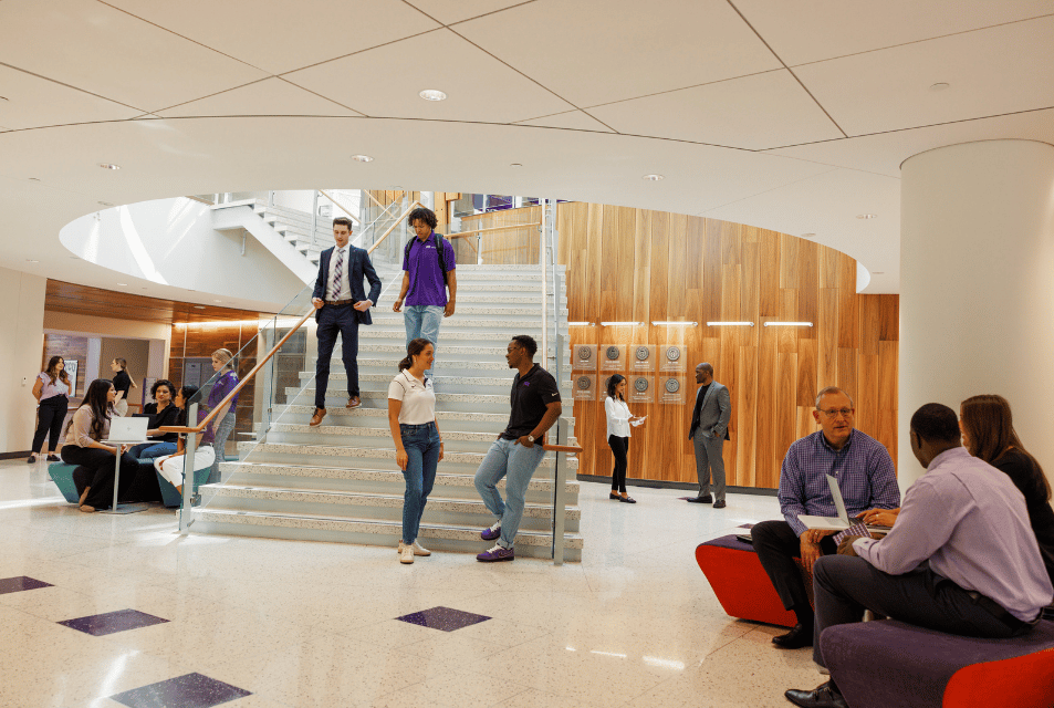 Students and faculty gather at the base of the stairway in Rogers Rotunda. 