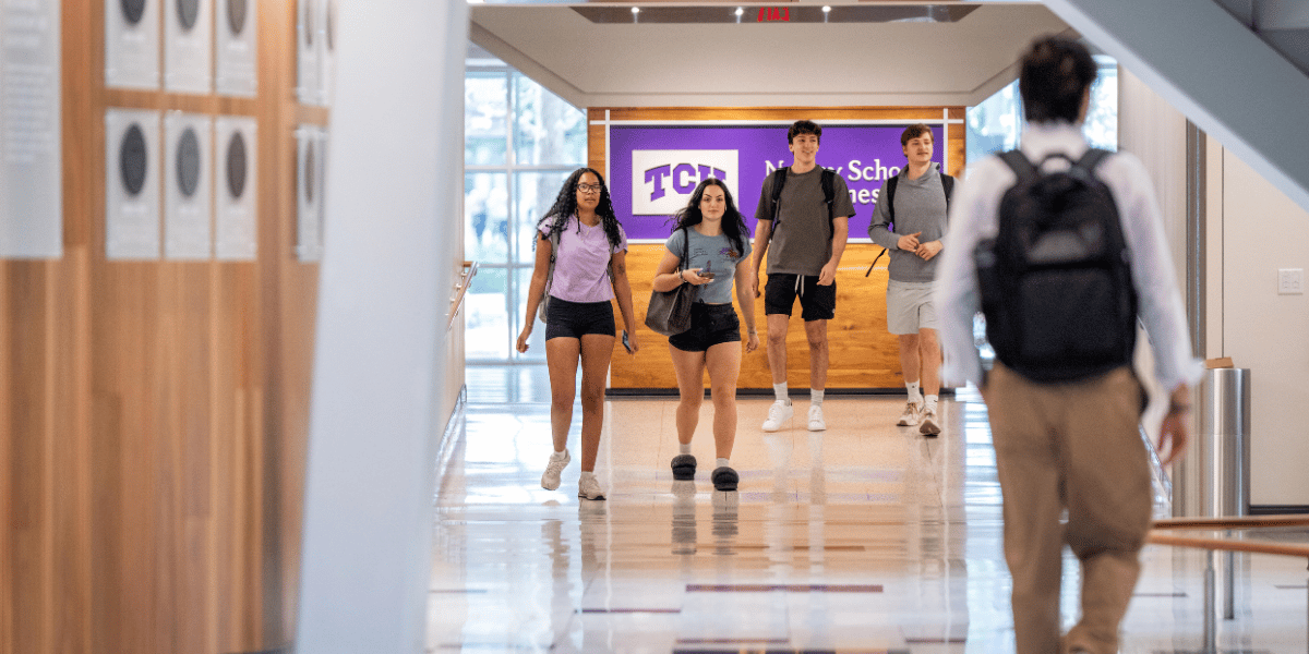 Undergraduate students walking on the first floor of Neeley between Tandy Hall and the Rogers Rotunda. 