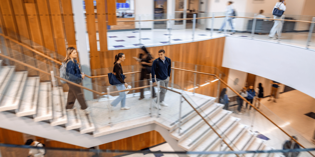 Undergraduate students walk on the Rogers Rotunda stairway at the center of Neeley's building.