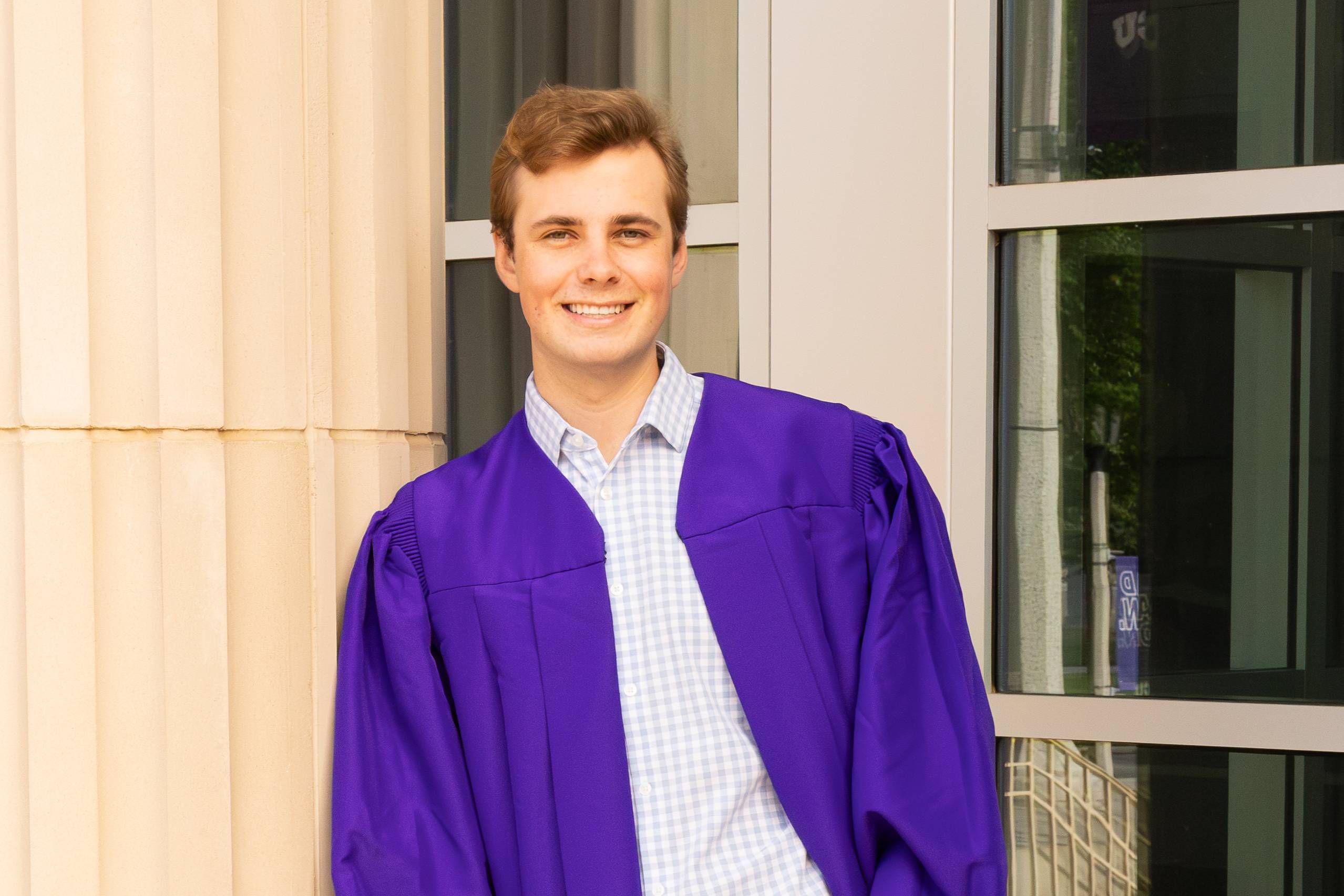Graduating student poses in cap and gown.